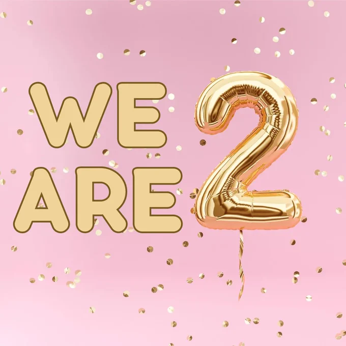 The background is pink with gold sparkles. The text says “we are 2” and is supposed to look like gold balloons
