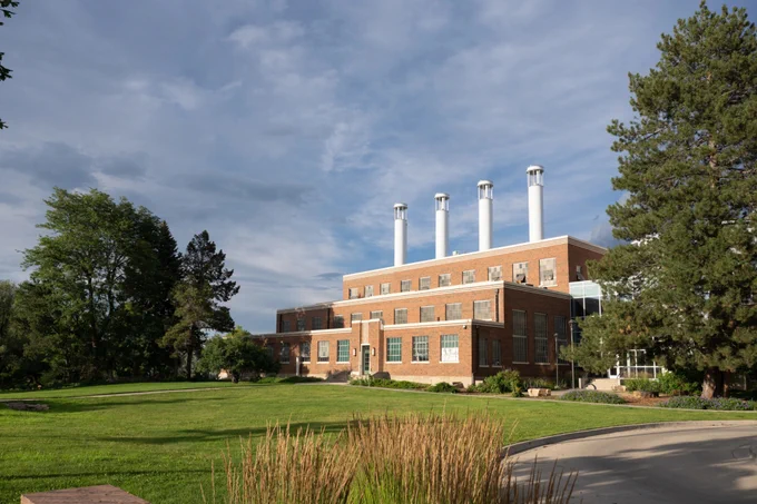 Colorado State University Powerhouse Energy Campus, located near the heart of downtown Fort Collins, stands amidst a green landscape under a blue sky.