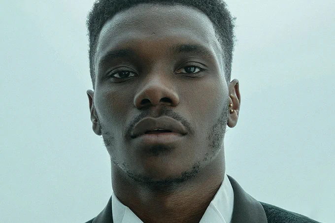 A photo showing a man's headshot against a pale blue background