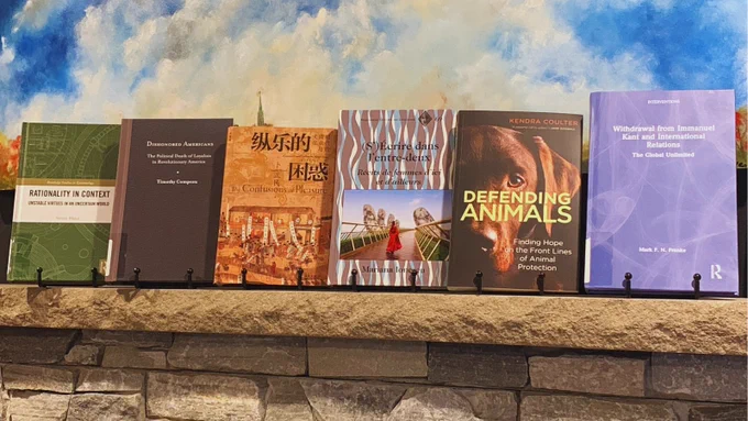 Books by faculty authors displayed above the fireplace in the Huron Commons. 