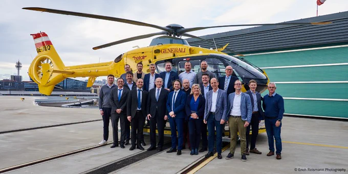 eine Gruppe von Menschen steht vor einem Hubschrauber
