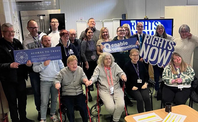Group picture at the event with ‘Rights Now!’ signs.