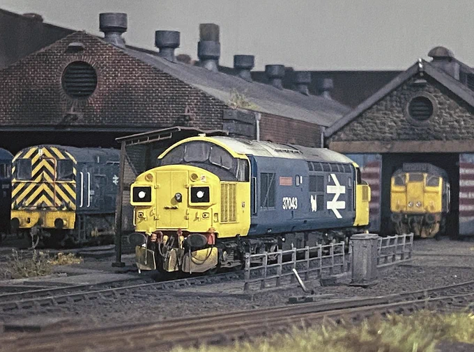 A model railway diorama of a maintenance depot, with a Class 37, Class 25 and Class 08 locomotive visible.