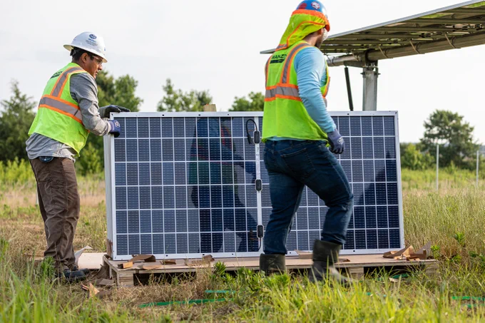 construction workers moving solar module