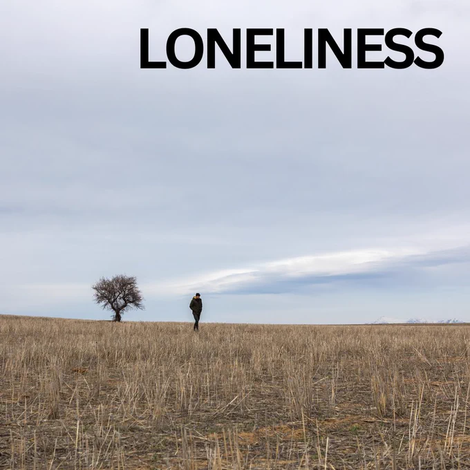 Image is of a field with a tree and a person far off in the distance. The text reads: loneliness.