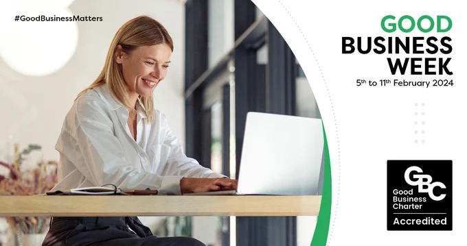 This is a promotional banner for Good Business Week, 5 - 11 February 2024. It shows a smiling woman, sitting at a desk working on a laptop.