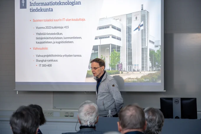 Kuvassa Teekkariystävät kuuntelevat, kun professori Lauri Kettunen kertoo heille informaatioteknologian tiedekunnasta.