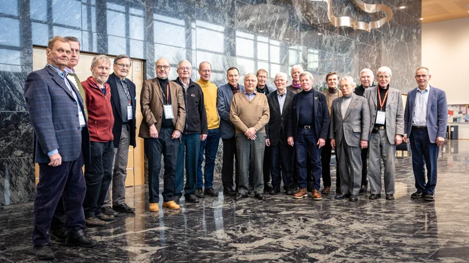 Otaniemen teekkariystävät yhteiskuvassa professori Pekka Neittaanmäen kanssa Jyväskylän yliopiston Agora-rakennuksen aulassa.