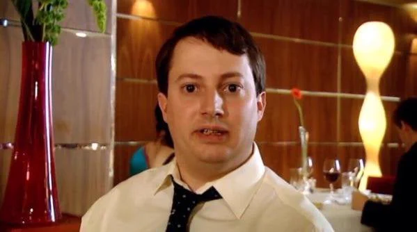 A still of Mark Corrigan from Peep Show looking shocked at the news that Jeremy ordered 4 naans