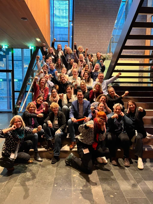 group of amazing deaf international professionals - social workers, psychiatrists, counselors, psychologists in mental health on the stairs signing deaf power at the joining Forces Congress in Haarlem 
