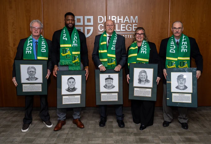 Al Fournier, Anthony Batchelor, Sam Dempster, Julie Pickell (Collins) and Colin Dempster posing with their frames and scarfs as the newest members of the Durham College Sports Hall of Fame.