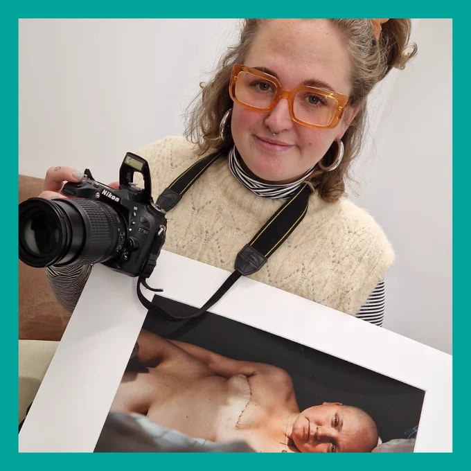 Mia holding a photo of herself and a camera