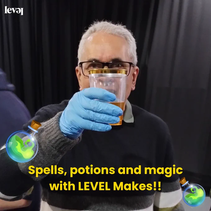 People using food colouring to create colourful potions in transparent cups. Some are pouring water into the cups and some hold them up to show the camera.
