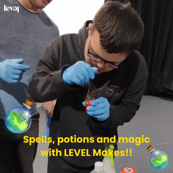 People using food colouring to create colourful potions in transparent cups. Some are pouring water into the cups and some hold them up to show the camera.
