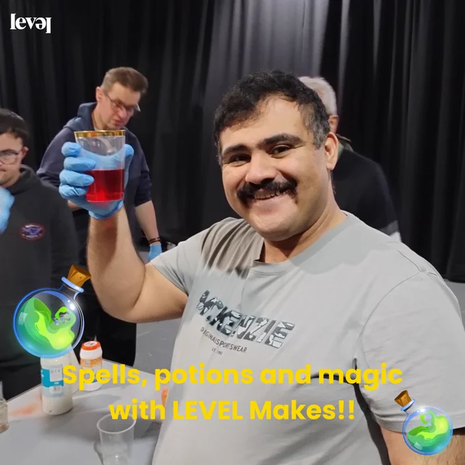 People using food colouring to create colourful potions in transparent cups. Some are pouring water into the cups and some hold them up to show the camera.
