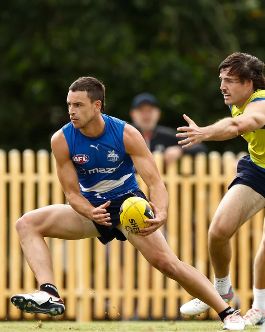 Luke Davies-Uniacke evades North Melbourne Reserves and train-on player Tyler Sellers.
