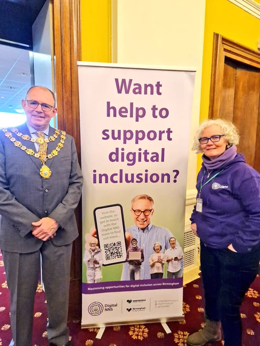 Councillor Tony Briggs, Mayor of Sutton Coldfield, with Pauline Roche, Community Lead, Digital NNS, either side of a popup at a community event 