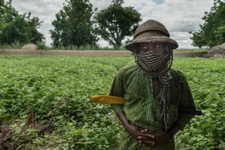 Image credit: Claire Jeantet - Fabrice Caterini / Inediz

Caption: Aliyu, a 27-year-old noma survivor, stands next to his home, in a village in Sokoto State, Nigeria. Aliyu says he usually covers his face with a veil to protect his wound from the sun or dust when he takes care of his cattle, but also due to shyness and discrimination he has experienced in the past.