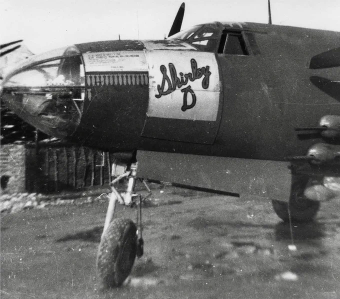 An old black and white photograph of the side of the Shirley D plane with the writing shown on the side of the plane as well as the nose and front wheel