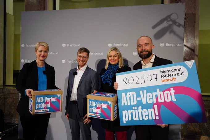 Manuela Schwesig neben Thomas und Gregor und einem großen Plakat, auf dem die Zahl der Stimmen (802907) steht. 