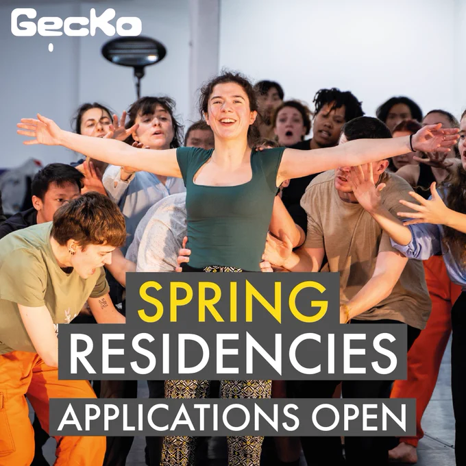 A large group of people stand in a studio behind a woman who is holding her arms out beside her, falling slowly towards the group who are ready to catch her. Text on the image reads: Spring Residencies, Applications Open.