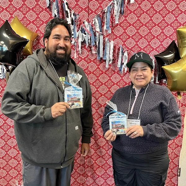 2 smiling teachers holding In N Out meal cards