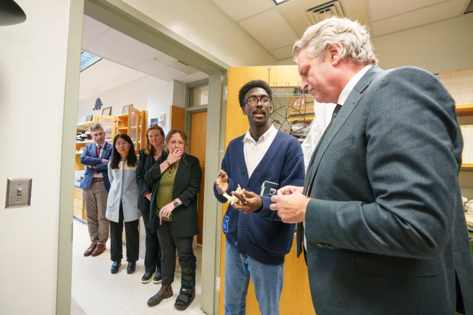Sola Johnson explains his research to Chancellor Diermeier. 