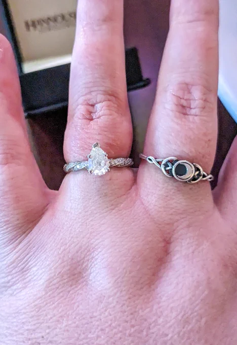 A woman's left hand with a diamond engagement ring.