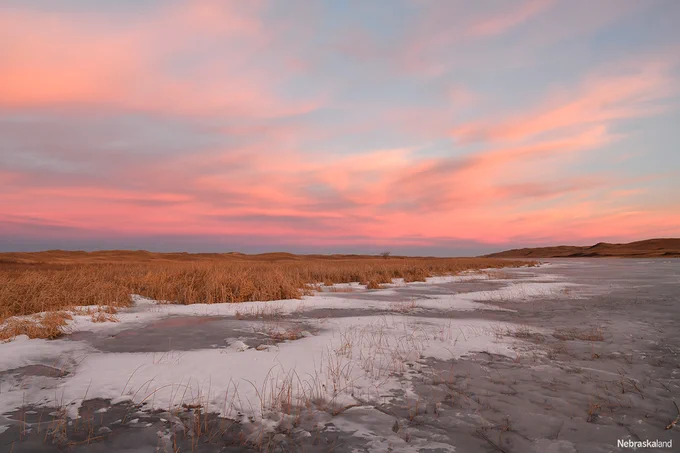 Ice and snow covers West Long Lake on the Valentine National Wildlife Refuge in Cherry County as the sun sets in the sandhills