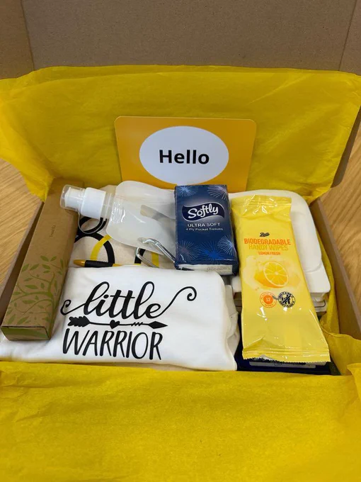 A picture of our parent pack, it’s a box lined with yellow tissue paper and filled with a baby grow, water pouch, toiletries and information leaflets.