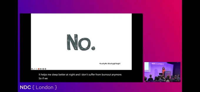 Livestream displaying a camera shot of the speaker while primarily displaying the current presentation slide, “No.” in large artistic font on a white background.