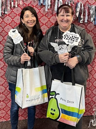 2 teachers smiling holding PearDeck bags while holding ChET Day signs