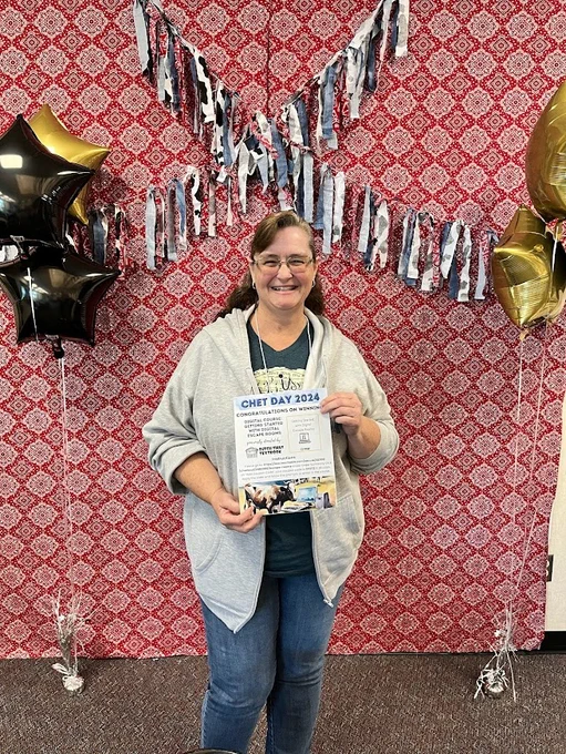 A smiling teacher holding a Ditch That Textbook course certificate