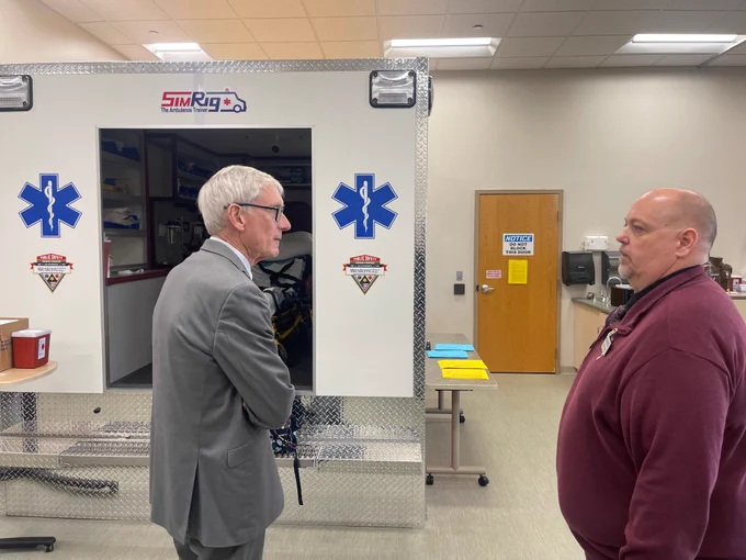 Gov. Evers talks with Dean Of Health And Public Safety Kevin Dean in front of an ambulance used for training at Western Tech.
