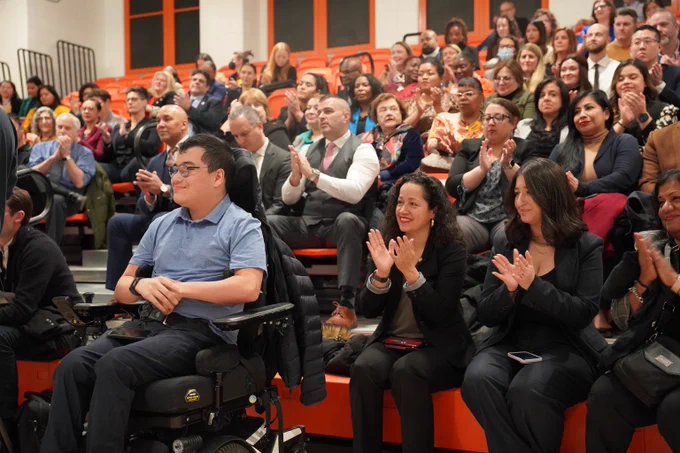 Group of people clapping inside of PS 958 for a Special Education Announcement.