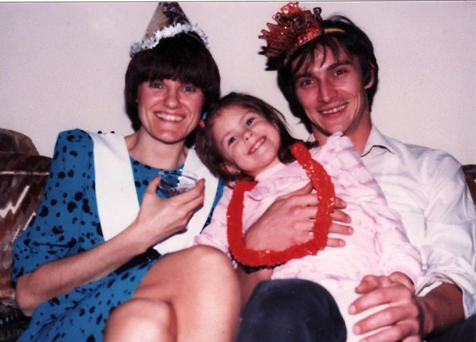 Fotografía de mediados de la década de 1980 donde aparecen Katalin Karikó, su marido, Béla Francia, y su hija, Susan Francia. Están ataviados con gorros y collares de papel propios de una fiesta. 