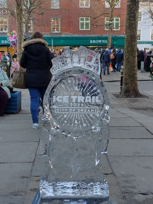 An ice sculpture of a dream catcher has text within the center that reads "York Ice Trail 2024, City of Dreams"