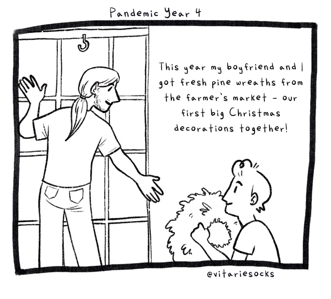 A black and white cartoon comic titled Pandemic Year 4. This is panel 1. A boy with short hair — Joey, the author of the comic — is holding a Christmas wreath and handing it to his boyfriend, a boy with long hair and a beard, who is standing in a window while decorating. The text reads: This year, my boyfriend and I got fresh pine wreaths from the farmer’s market — our fist big Christmas decorations together!