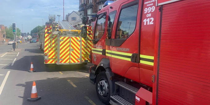 A photo of two fire engines parked on a road while dealing with an incident