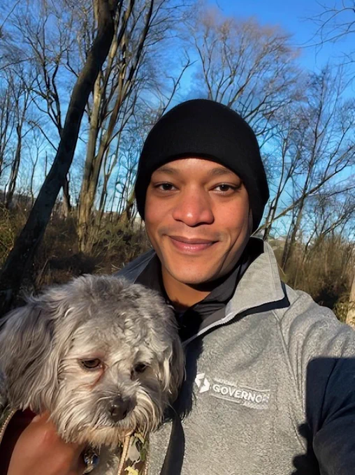 Governor Moore wearing black beanie and holding Tucker in one hand at Tuckahoe State Park