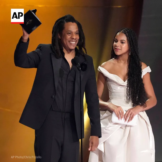 Jay-Z, left, accepts the Dr. Dre Global Impact Award as daughter Blue Ivy Carter, looks on during the 66th annual Grammy Awards. 