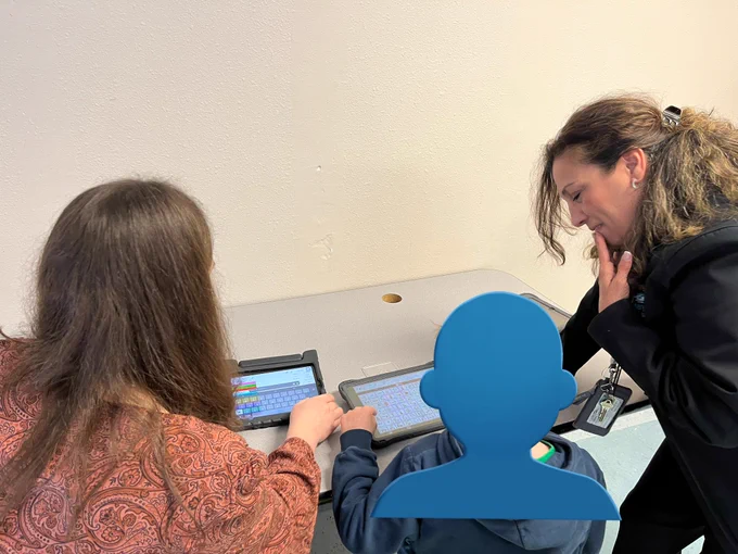 Three people, gathered at a table, learning and communicating on iPads.