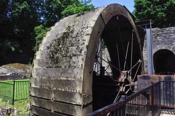 The large water wheel at Aberdualis tinworks on a sunny day. The wheel is off.