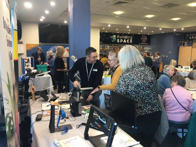 Jason at the VisionAid table demonstrating our low vision solutions.