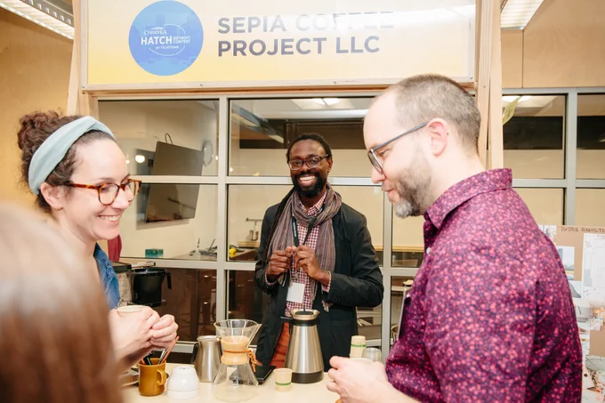 Two people talk to the owner of Sepia Coffee Project LLC at the 2023 Comerica Hatch Detroit Contest Top 10 Reveal