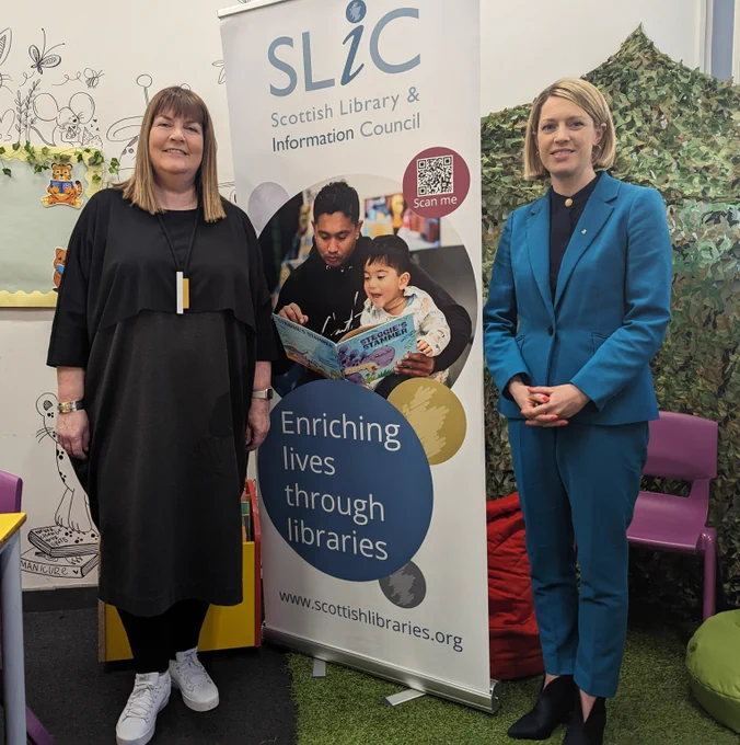 Education Secretary Jenny Gilruth stands next to SLIC sign alongside Pamela Tulloch of the Scottish Library & Information Council
