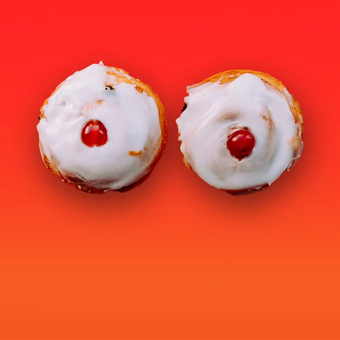 Two Cherry Bakewells suggestively displayed on a bright orange background.