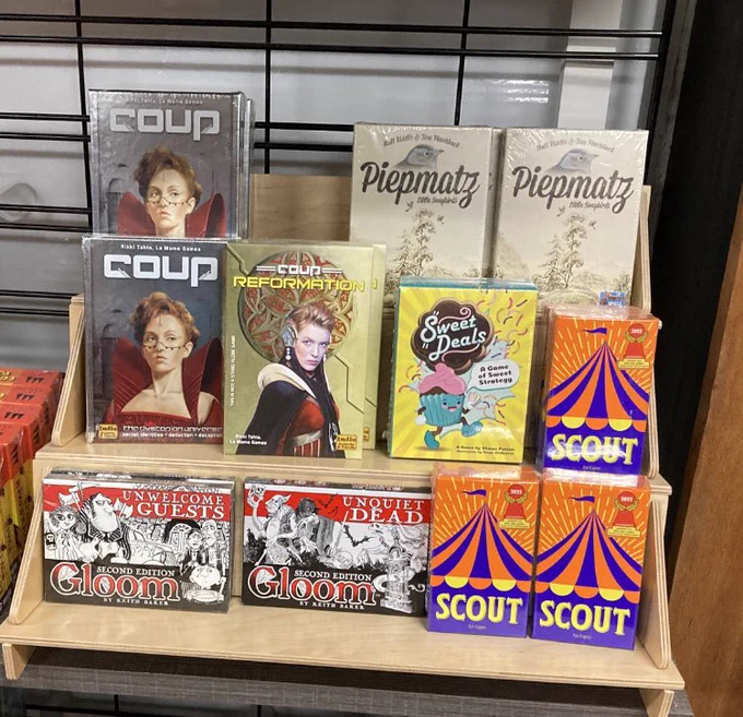 Store display showing mini games, including coup, gloom, scout, and sweet deals