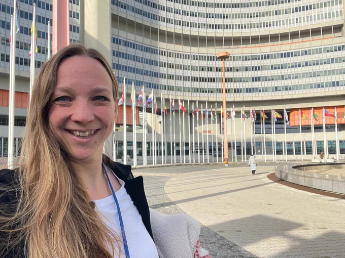 Selfie of Mariel Borowitz at the United Nations in Vienna building with international flags