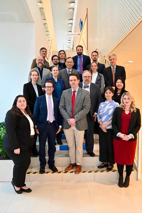 U.S. delegation (18 men & women in business dress) assembled on a stairway